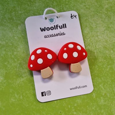 A green background with a pair of mushroom shaped point protectors mounted on a white card.