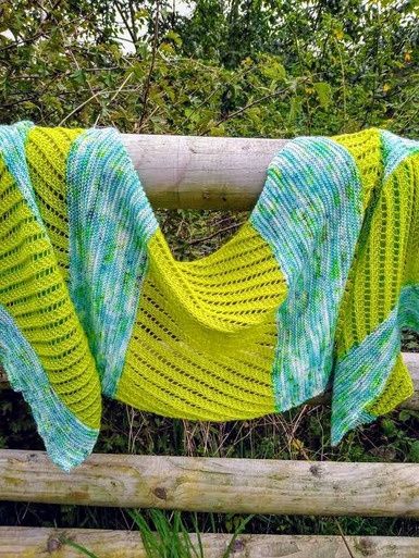 A knitted shawl in lime green and aqua blue blocks.
