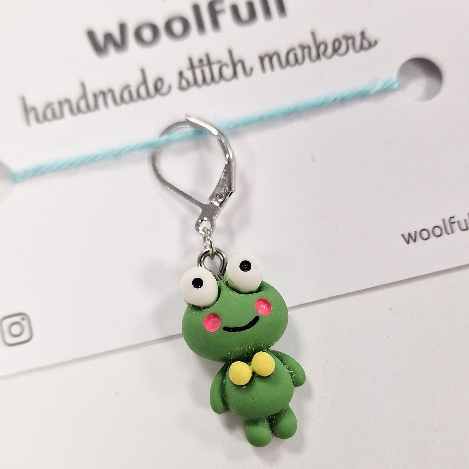 A green frog shaped stitch marker.