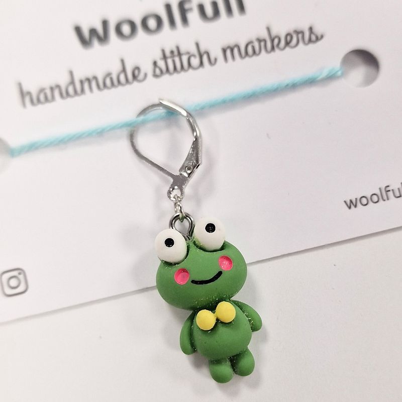 A green frog shaped stitch marker.