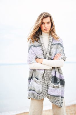 A woman is wearing a grey and purple knitted shawl.
