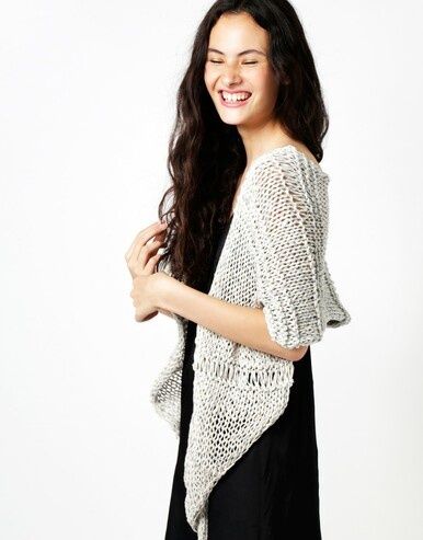 A woman is wearing a pale grey knitted shawl.