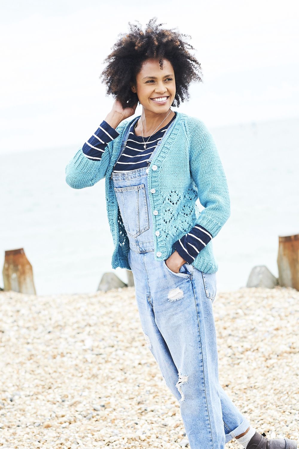 A woman is wearing a blue knitted cardigan with lace detail.