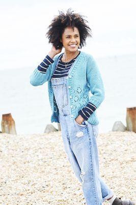 A woman is wearing a blue knitted cardigan with lace detail.