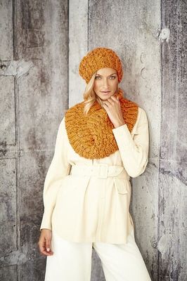 A woman is wearing an orange knitted hat and snood.