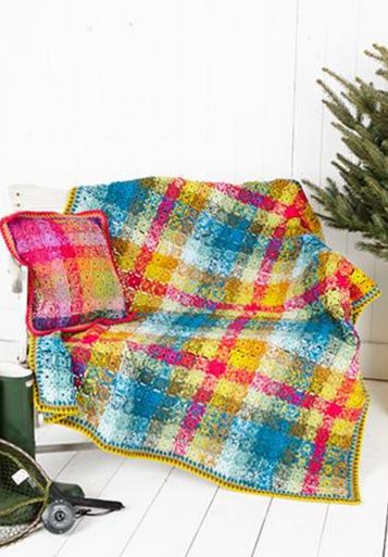 A crocheted blanket made up of small colourful squares, in a layout designed to mimic tartan.