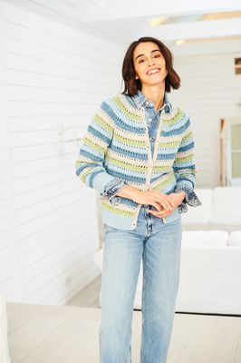 A woman is wearing a striped knitted cardigan in shades of cream, blue and green.