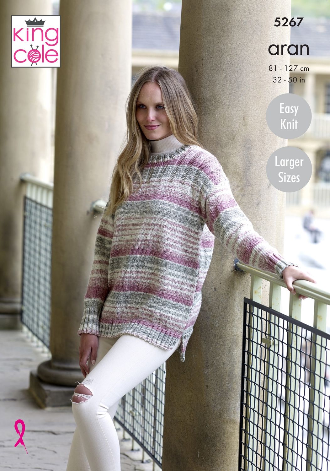 A woman is wearing a knitted sweater in a variegated pink and grey yarn.