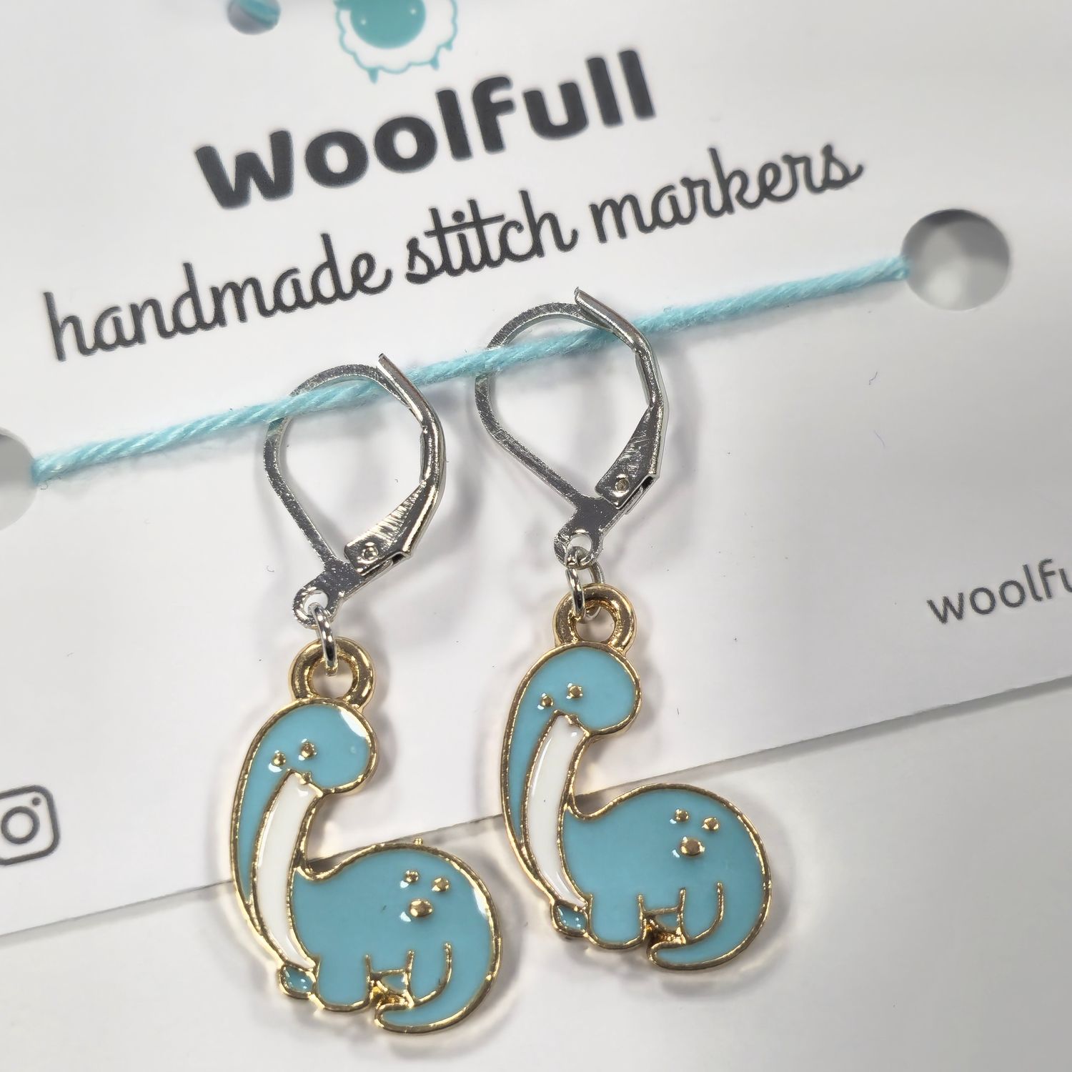 2 blue dinosaur shaped stitch markers.