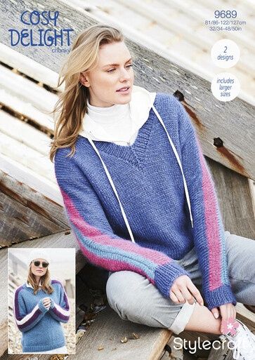 A woman is wearing a blue knitted sweater with pink stripes on the sleeves.