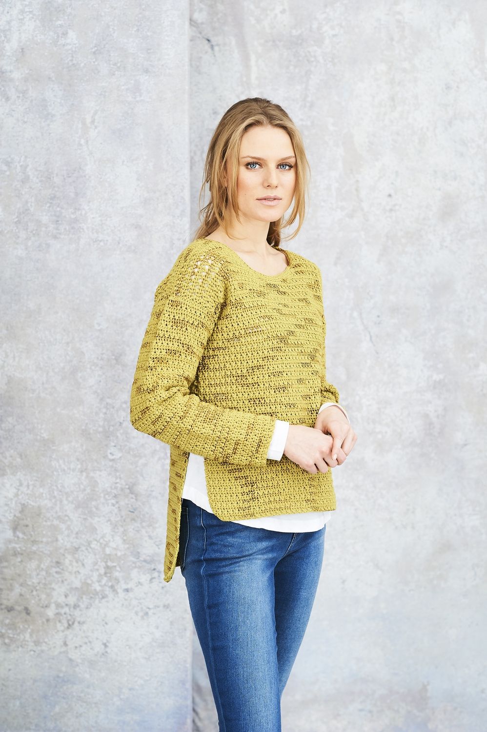 A woman is wearing a lime green crocheted sweater.