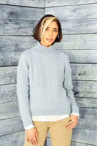 A woman is wearing a light blue knitted sweater.