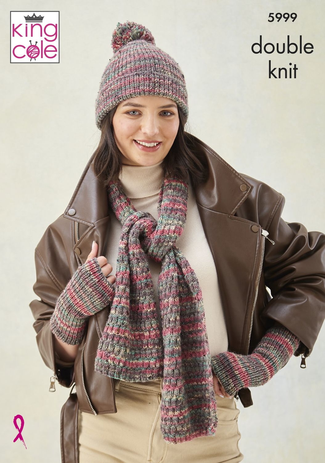 A woman is wearing a knitted scarf, hat and wristwarmers in shades of red, green and beige.