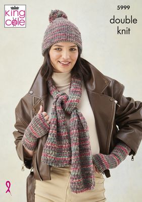 A woman is wearing a knitted scarf, hat and wristwarmers in shades of red, green and beige.