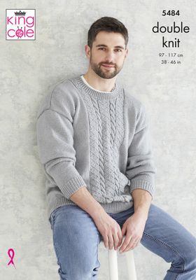 A man is wearing a grey knitted sweater with cable detail down the front.