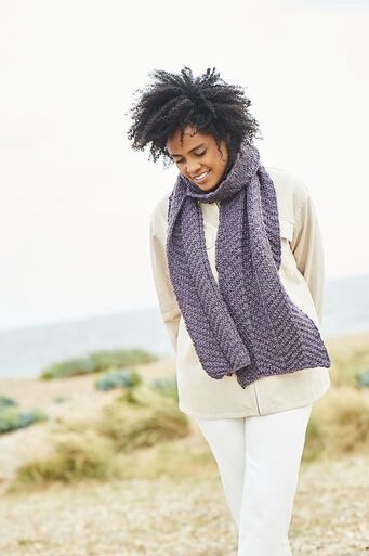 A woman is wearing a purple knitted scarf.