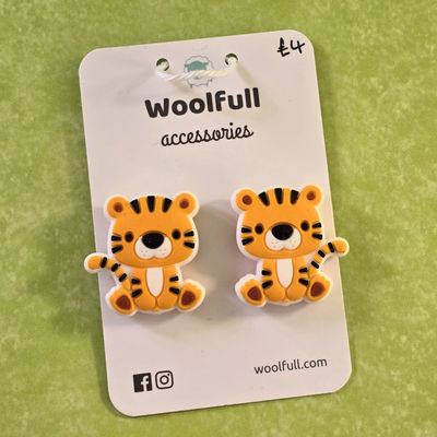 A green background with a pair of tiger shaped point protectors mounted on a white card.