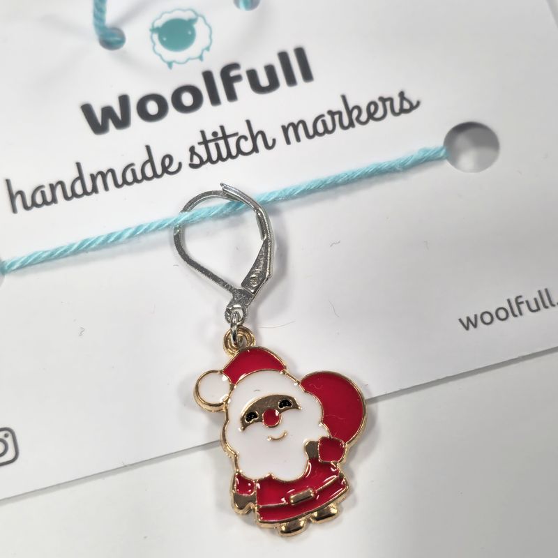 A red and white santa shaped stitch marker.