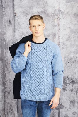 A man is wearing a blue cable knit sweater.