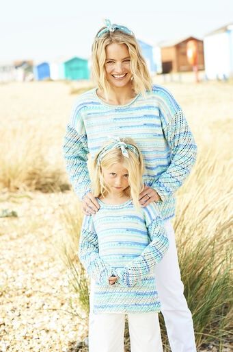 A woman and a girl are wearing matching knitted sweaters in a variegated blue yarn.