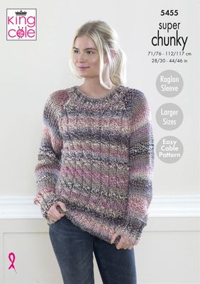 A woman is wearing a knitted sweater in a variegated pink and grey yarn.
