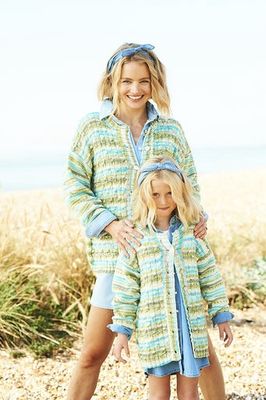 A woman and a girl are wearing matching knitted cardigans in a variegated blue and green yarn.