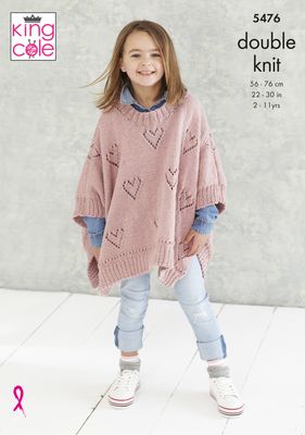 A girl is wearing a pink knitted poncho with lace heart detail on the body.