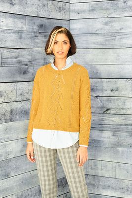 A woman is wearing a mustard yellow knitted sweater.