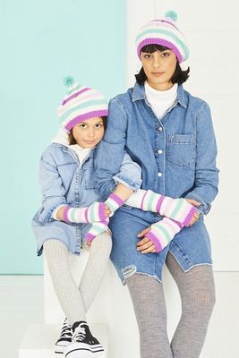A woman and a girl are wearing matching cream, pink, purple and blue stripy knitted hats and wristwarmers.