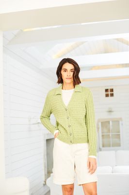 A woman is wearing a knitted cardigan in pale green.