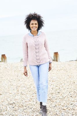 A woman is wearing a pink knitted sweater with lace detail.
