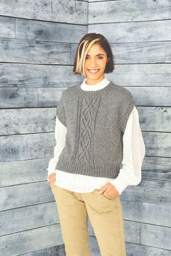 A woman is wearing a grey knitted tank top.