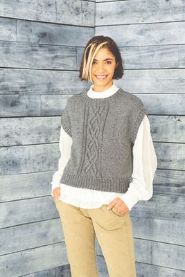 A woman is wearing a grey knitted tank top.