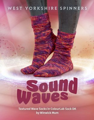 Someone wearing a pair of knitted socks in a variegated pink, purple and orange yarn on a pink background, and text that reads &#39;Sound Waves&#39;.