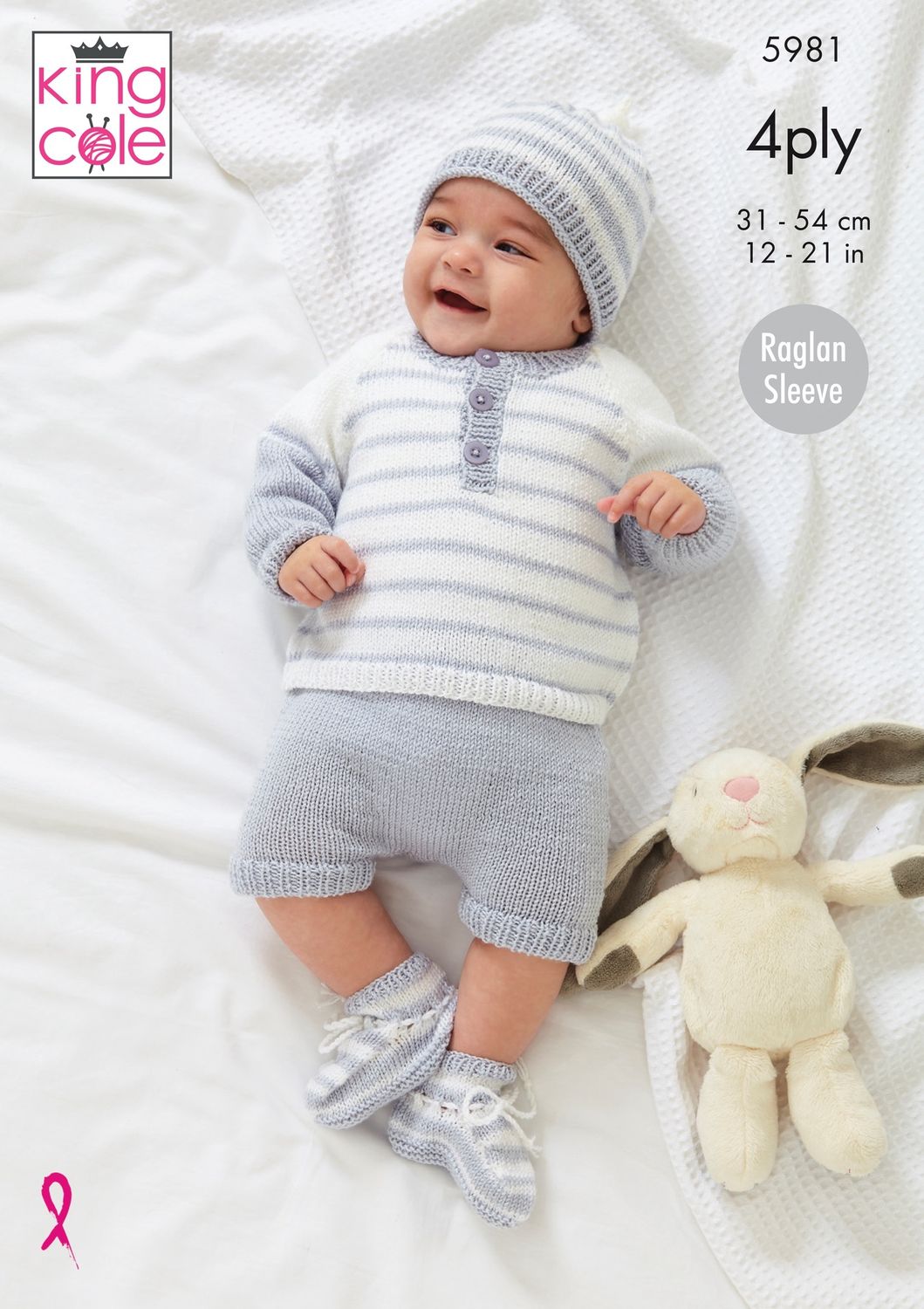 A baby is wearing a white and silver knitted sweater, with matching shorts, hat and bootees.