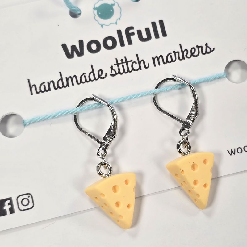 2 yellow cheese wedge shaped stitch markers.