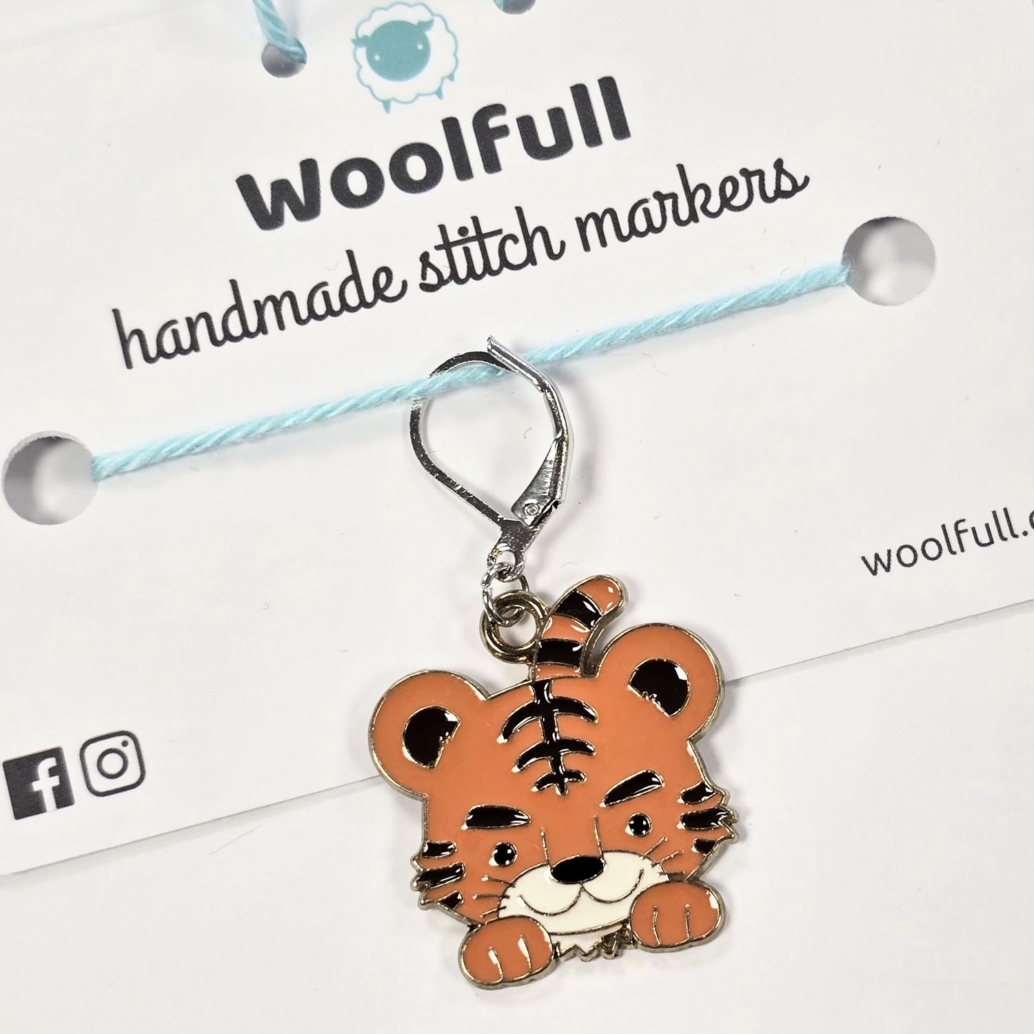 An orange tiger shaped stitch marker.
