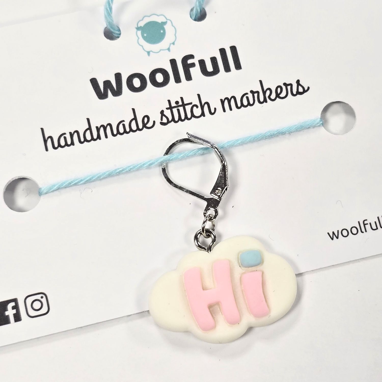 A pink &#39;Hi&#39; on a white cloud shaped stitch marker.