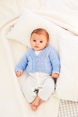 A baby is wearing a blue cable knit cardigan.