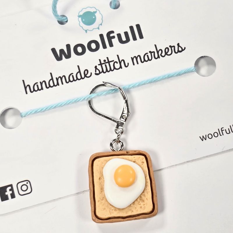 An egg on a slice of toast shaped stitch marker.