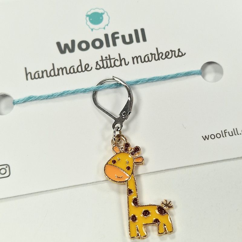 An enamel giraffe shaped stitch marker.