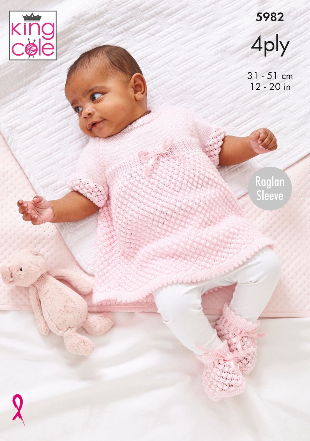 A baby is wearing a pale pink knitted top and matching bootees.