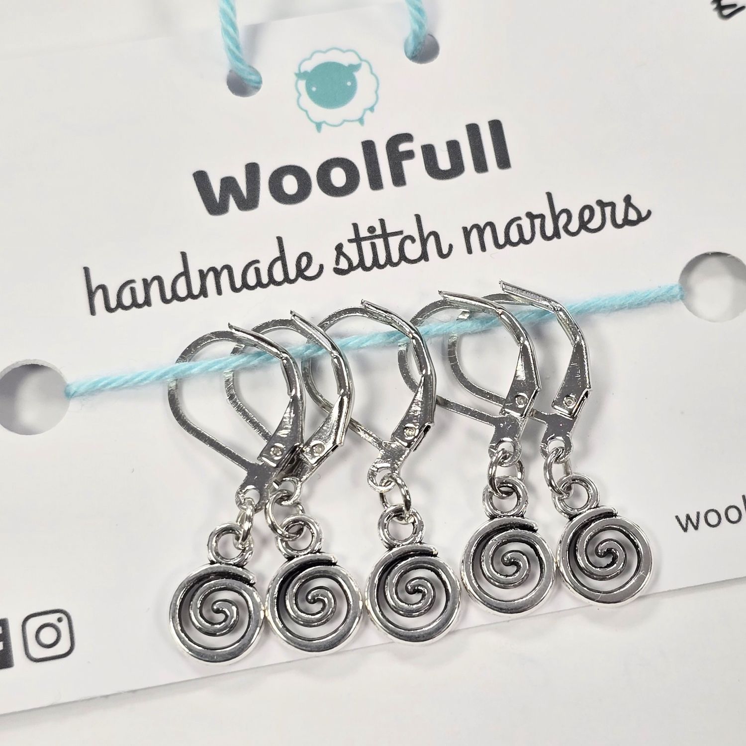 5 silver metal spiral shaped stitch markers.