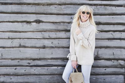 A woman is wearing a cream knitted sweater.