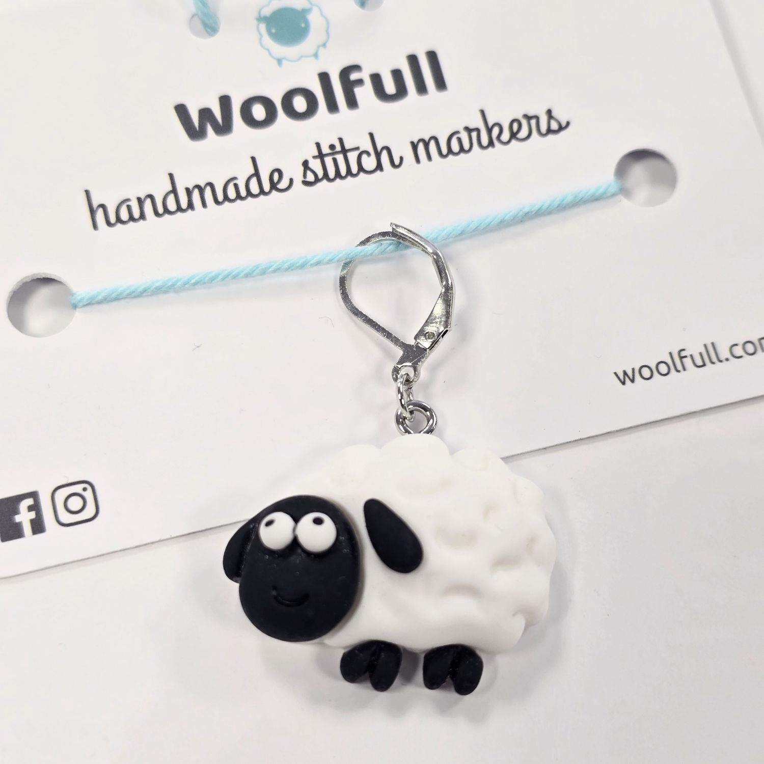 A black and white sheep shaped stitch marker.