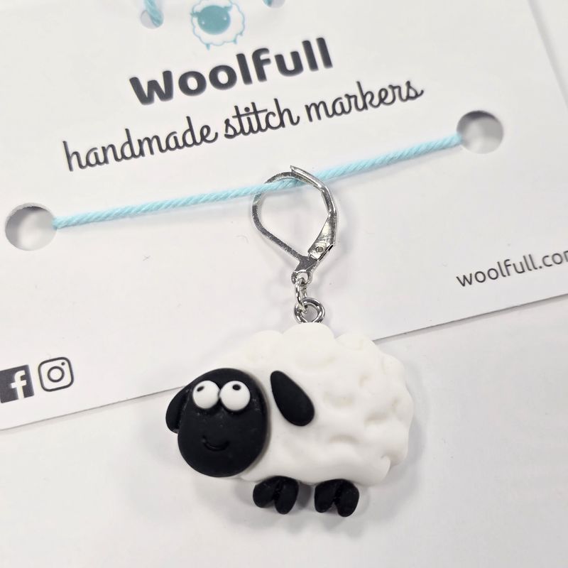 A black and white sheep shaped stitch marker.