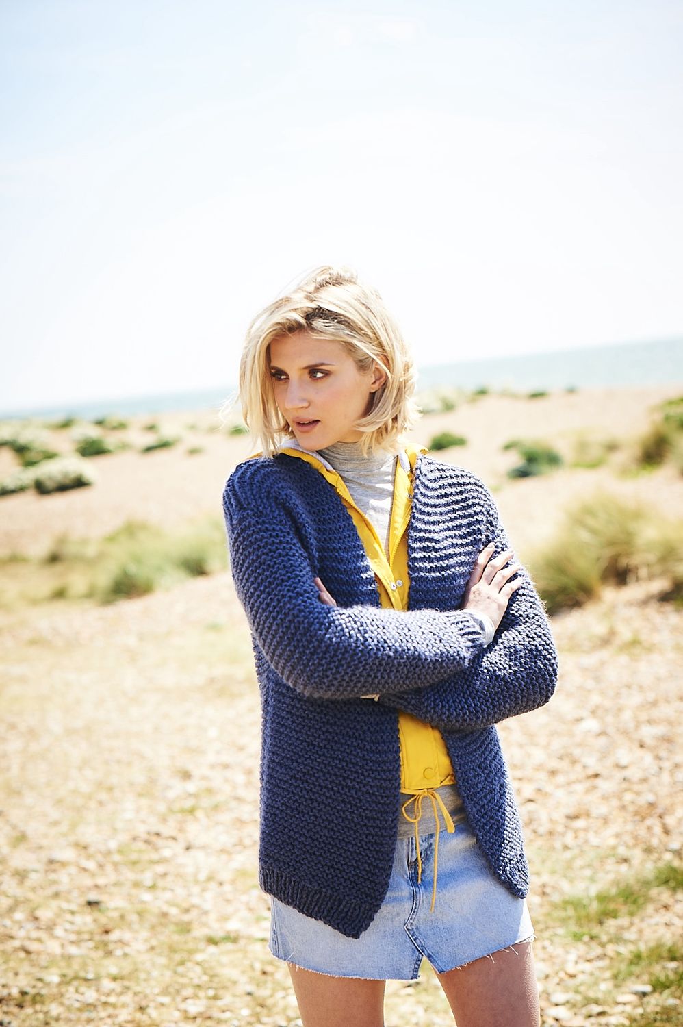 A woman is wearing a navy blue knitted cardigan.