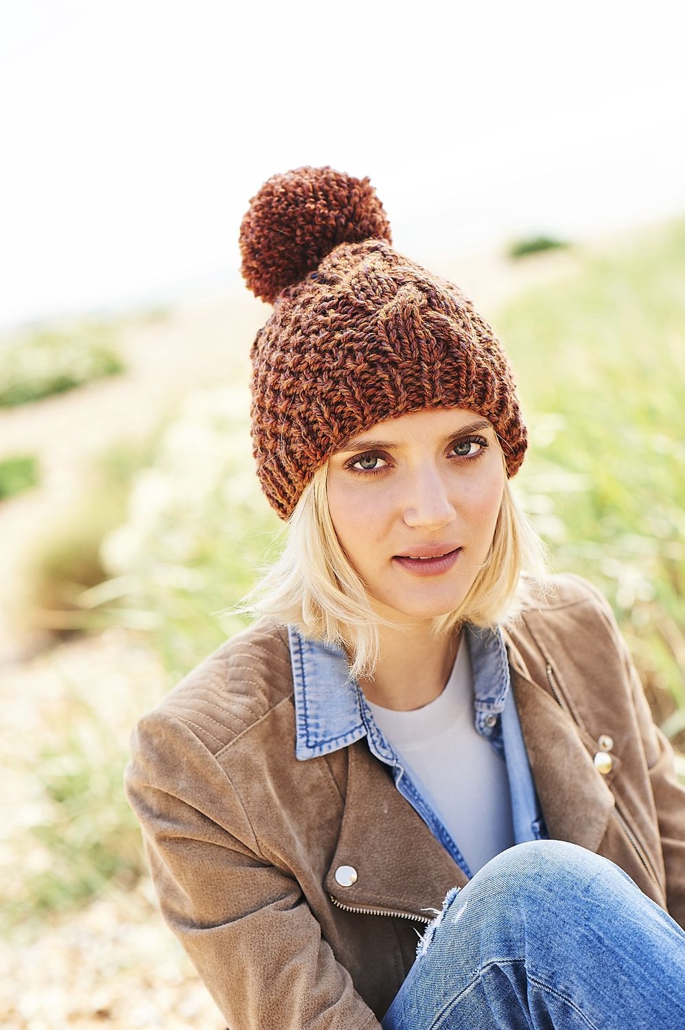 A woman is wearing a brown knitted hat.