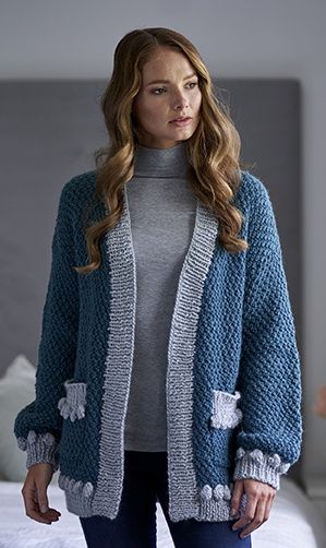 A woman is wearing a blue and silver knitted cardigan.