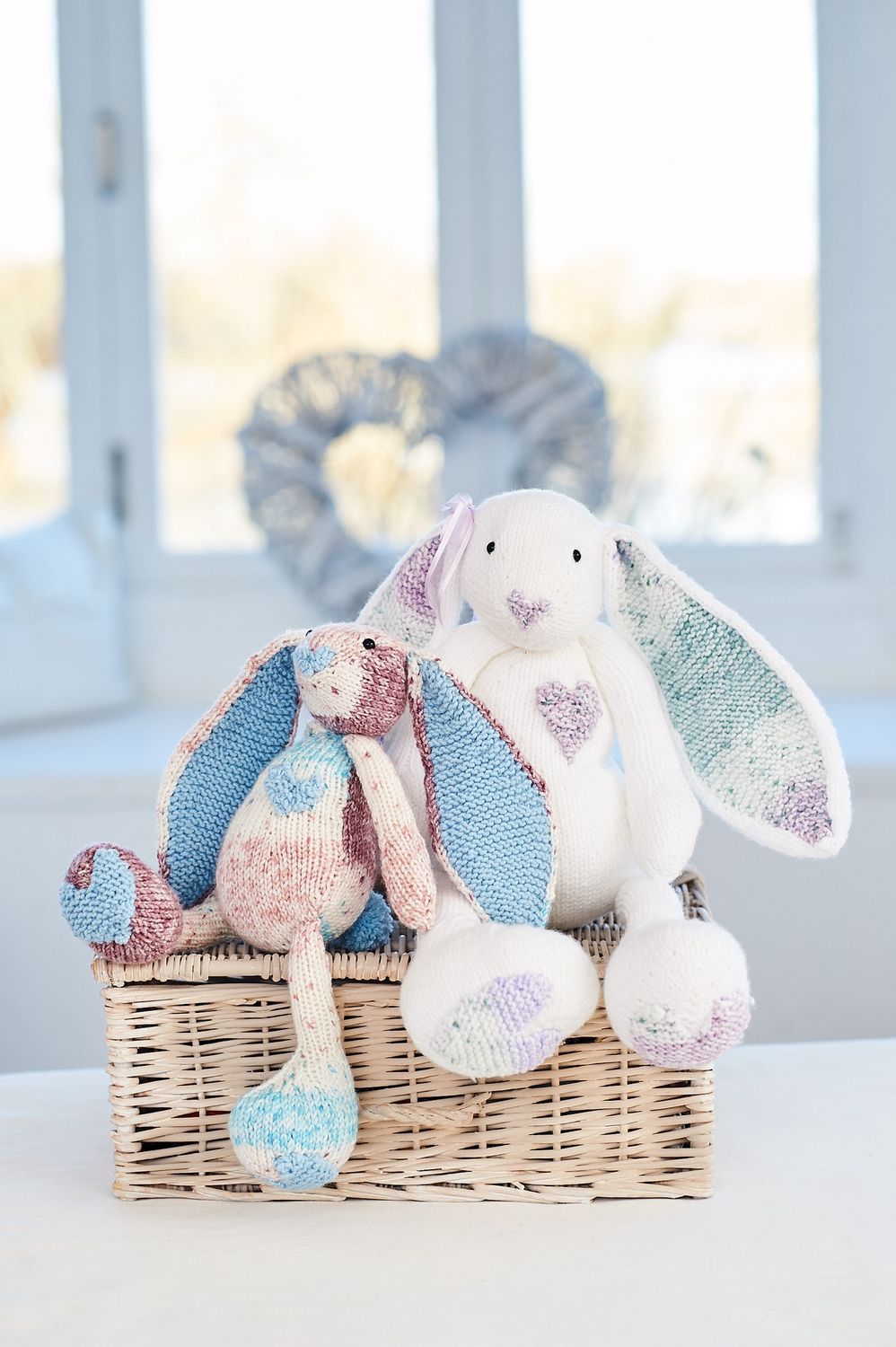 2 knitted rabbits in variegated yarn.
